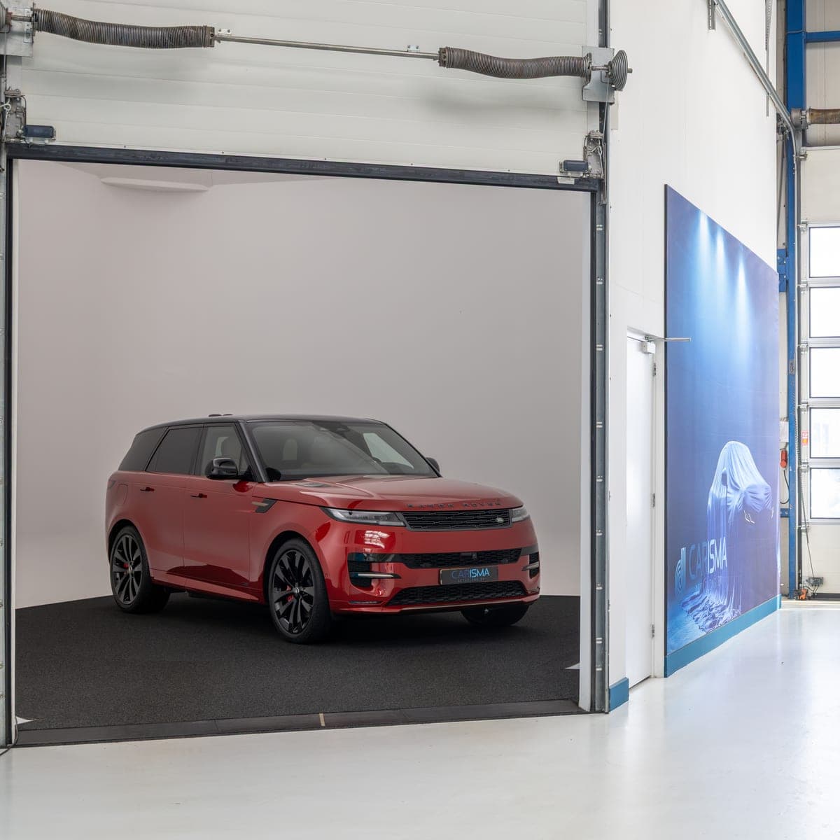 Een rode Range Rover in de fotostudio met een egale achtergrond