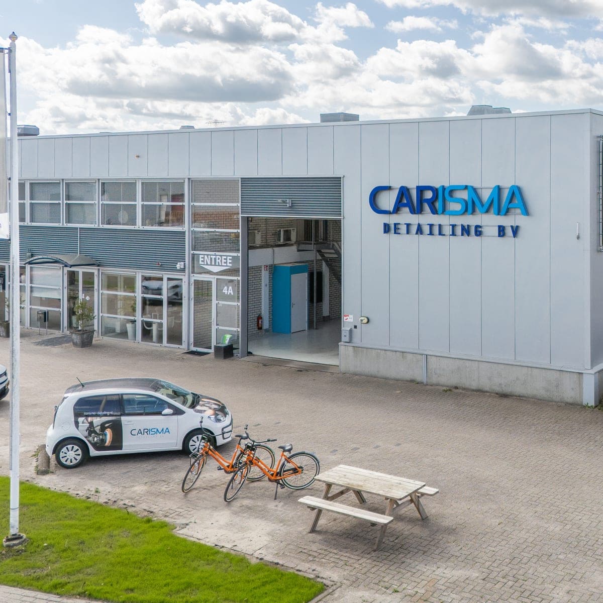 Het bedrijfspand van Carisma Detailing aan de Malmöweg 4A, met de gevelnaam, de entree en de bedrijfsbus op het terrein